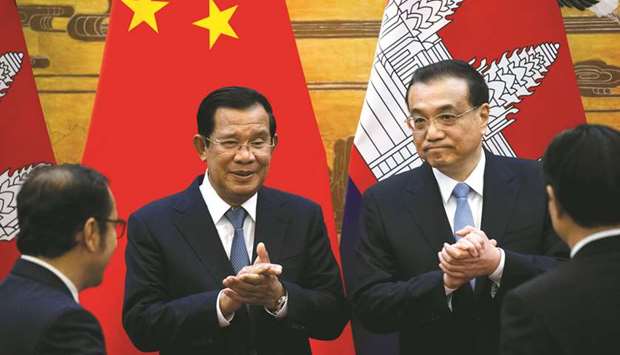 Cambodian Prime Minister Hun Sen applauds with Chinese Premier Li Keqiang during a signing ceremony at the Great Hall of the People in Beijing. China has promised 4bn yuan ($588mn) in aid to Cambodia, Hun Sen said yesterday.