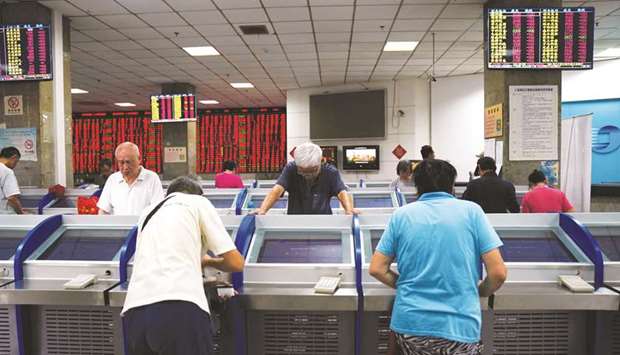 Investors look at computer screens showing stock information at a brokerage house in Shanghai. The Shanghai Stock Exchange index  finished 1.2% lower at 2,579.70 points yesterday.