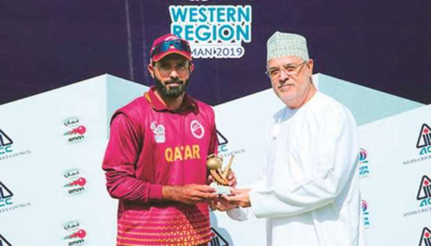 Qatar batsman Mohamed Tanveer receives his Man of the Match award from Ali Moosa of Oman Cricket Association.