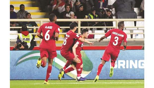 Bassam al-Rawi is congratulated by teammates after he scored the winner against Iraq yesterday.