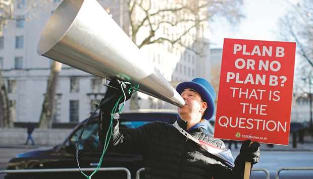 Anti-Brexit campaigner Steve Bray holds a placard as he demonstrates with a megaphone outside the Houses of Parliament in central London yesterday.