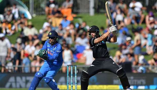 New Zealand's Doug Bracewell (R) plays a shot as India's wicketkeeper Mahendra Singh Dhoni (L) looks on, during the first one-day international (ODI) cricket match