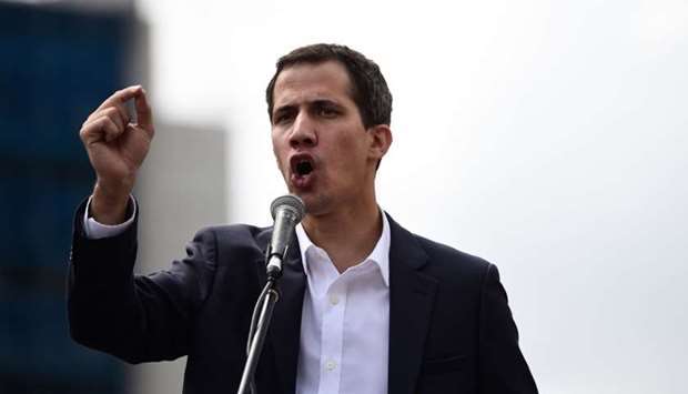 Venezuela's National Assembly head Juan Guaido speaks to the crowd during a mass opposition rally against leader Nicolas Maduro in which he declared himself the country's ,acting president,, on the anniversary of a 1958 uprising that overthrew military dictatorship, in Caracas