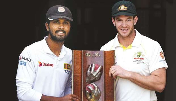 Sri Lankau2019s captain Dinesh Chandimal (left) and his Australian counterpart captain Tim Paine pose with the Warne-Murali Test trophy at The Gabba in Brisbane yesterday. (AFP)