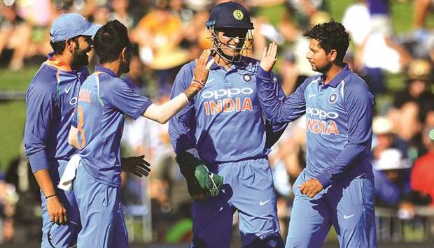 Indiau2019s Kuldeep Yadav (right), celebrates with teammates (from left) Rohit Sharma, Yuzvendra Chahal and wicketkeeper Mahendra Singh Dhoni after taking the wicket of New Zealandu2019s Lockie Ferguson in the first ODI at McLean Park in Napier. (AFP)
