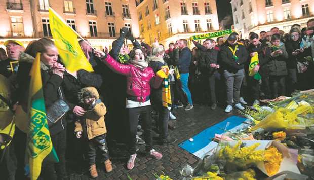 FC Nantes fans gather for a vigil in the western French city yesterday, placing flowers, scarves and flags on a fountain and chanting Argentinian forward Emiliano Salau2019s name. (AFP)
