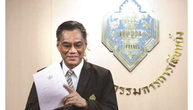 Thailandu2019s election commission chairman Ittiporn Boonpracong holds a document during a press conference in Bangkok announcing the holding of general elections yesterday.