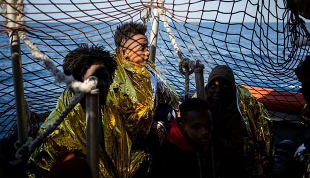 Rescued migrants from a group of 47, wrapped in survival blankets and including an underaged (C) are pictured aboard the Dutch-flagged vessel Sea Watch 3 during a rescue operation
