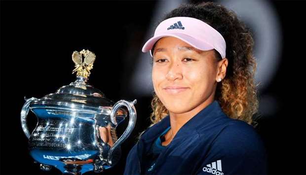Japan's Naomi Osaka celebrates with the championship trophy during the presentation ceremony after her victory against Czech Republic's Petra Kvitova in the women's singles final on day 13 of the Australian Open tennis tournament in Melbourne