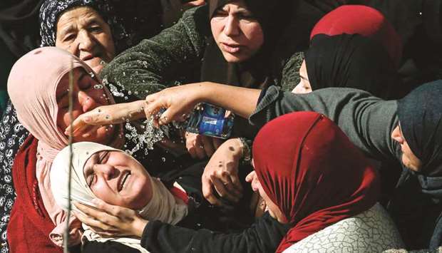 Palestinian women sprinkle water to comfort the mother of 17-year-old Palestinian Ayman Hamed, who was fatally shot by Israeli troops on Friday while throwing stones at Israeli motorists, at his funeral yesterday in the village of Silwad, 15km northeast of Ramallah.
