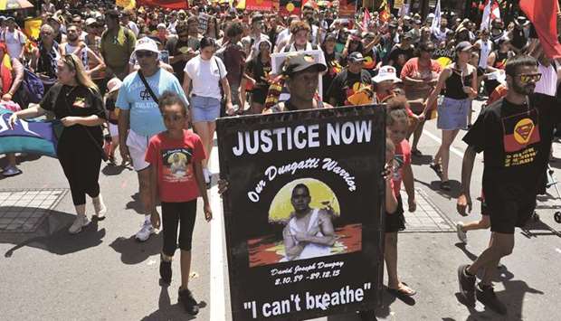 Protesters march through the streets of Sydney in an u201cInvasion Dayu201d rally on Australia Day yesterday.
