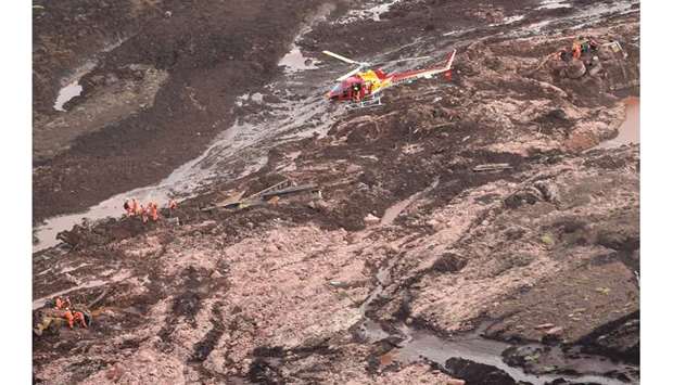 Aerial view showing firemen looking for people in heavy machinery (left and right) and a locomotive (centre) after the collapse of a dam which belonged to Brazilu2019s giant mining company Vale, near the town of Brumadinho in southeastern Brazil yesterday.