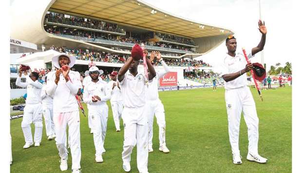 West Indiesu2019 players Roston Chase (left), Kemar Roach (centre) and Jason Holder (right) wave to supporters after winning first Test against England at Kensington Oval, Bridgetown, Barbados, on January 26. (AFP)