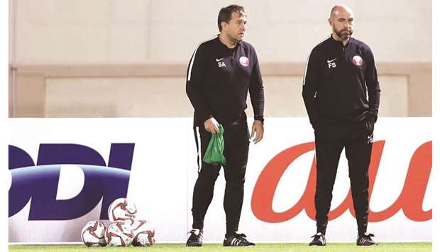 Qatar coach Felix Sanchez (right) and one of his assistants keep an close eye on the players during the training session in Abu Dhabi.