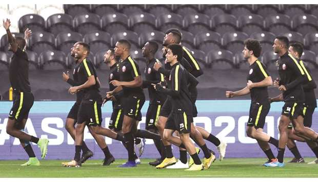 Members of the Qatar squad are all smiles as they are led by Abdelkarim Hassan during a training session in Abu Dhabi yesterday.