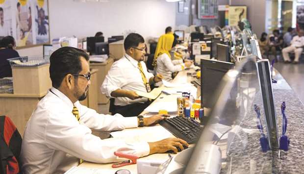 Employees work at a service counter inside a combined Malayan Banking Bhd (Maybank) and Maybank Islamic Bhd bank branch in Kuala Lumpur (file). It is expected that the market for Islamic banking software will grow further at a high rate beyond 2021 as Muslims continue to align their savings, investments and financing needs with Islamic principles, while more and more non-Muslims discover the benefits of participation or ethical banking that Islamic banking epitomises.