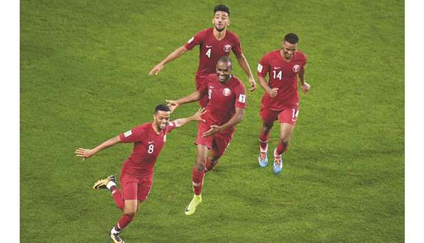Qataru2019s Hamid Ismail (left) celebrates his goal with teammates during the AFC Asian Cup semi-finals against the UAE in Abu Dhabi yesterday.