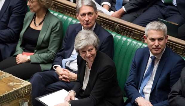 Britain's Prime Minister Theresa May (C) smiling in the House of Commons in London. AFP/UK PARLIAMENT/Jessica TAYLOR