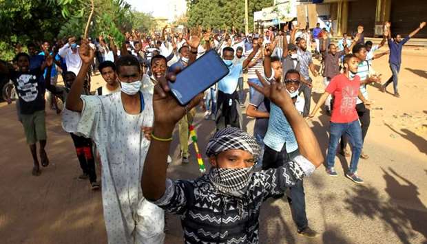 Sudanese demonstrators chant slogans as they march along the street during anti-government protests in Khartoum on December 25, 2018
