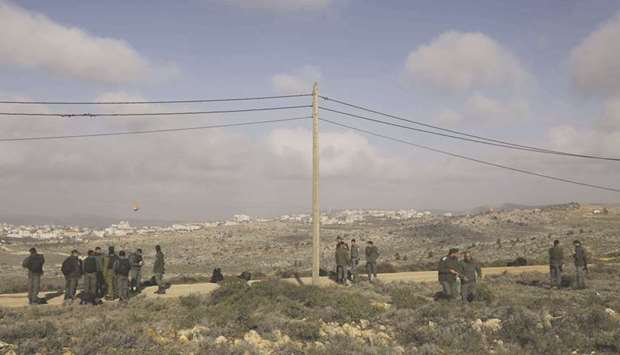 Members of the Israeli security forces gather at the former outpost of Amona near the Jewish settlement of Ofra, following clashes as dozens of settlers were evicted early yesterday.