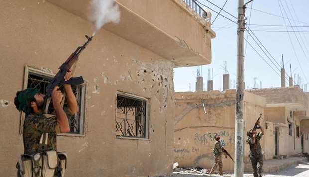 Kurdish fighters from the People's Protection Units (YPG) fire rifles at a drone operated by Islamic State militants in Raqqa, Syria. File picture: June 16, 2017