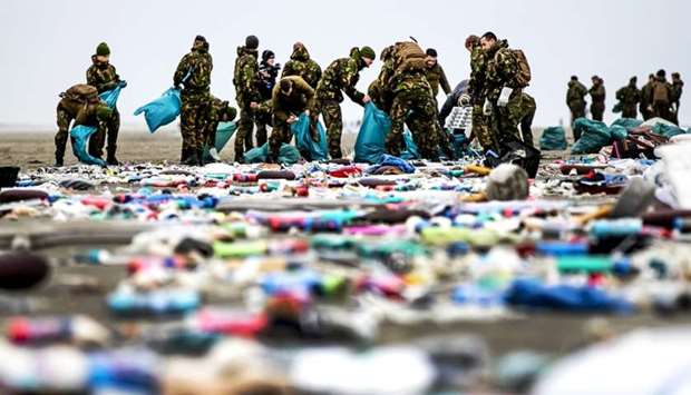 Netherlands' army soldiers take part in the cleaning of the coastline of Schiermonnikoog yesterday in the Dutch Frisian Island, two days after some 270 containers tumbled from the Panama-registered MSC Zoe, one of the world's biggest cargo ships in rough weather.