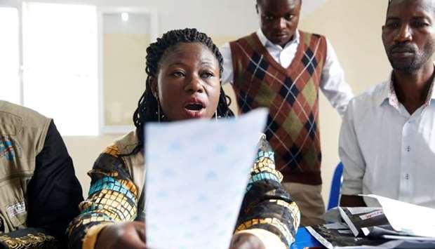 An official of Congo's Independent National Electoral Commission (CENI) reads out the presidential elections results of one polling station at a tallying centre yesterday in Kinshasa, Democratic Republic of Congo.
