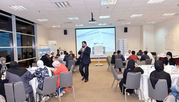 QIB employees interacting with students during the 'How Money Works?' session