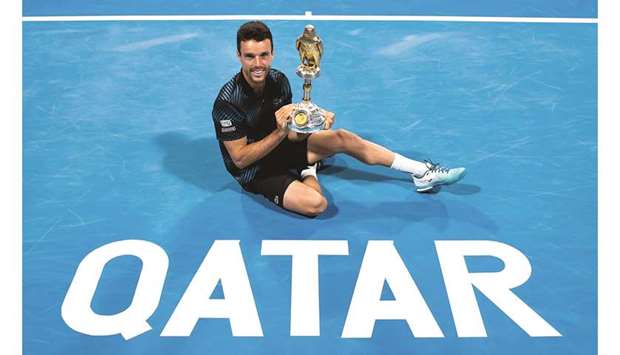Spainu2019s Roberto Bautista Agut poses with the Qatar ExxonMobil Open trophy yesterday after defeating Germanyu2019s Tomas Berdych 6-4, 3-6, 6-3 in the final at the Khalifa International Tennis and Squash Complex. Picture on the right shows, winner Bautista Agut (fourth from left), posing with runner-up Berdych (third from left), Alistair Routledge, president and general manager of ExxonMobil Qatar (L), Andrew P Swiger, senior vice president of Exxon Mobil Corporation (second from left), Nasser al-Kheleifi, president of Qatar Tennis Federation (second from right) and Karim Alami, the Tournament Director. PICTURES: Noushad Thekkayil