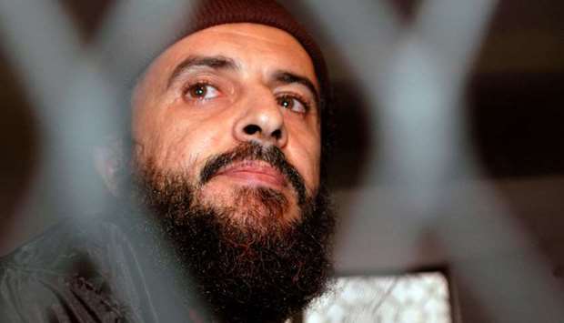 Yemeni militant Jamal al-Badawi looks from behind bars during the first hearing of a Sana'a court of appeals hearing in Yemen December 8, 2004