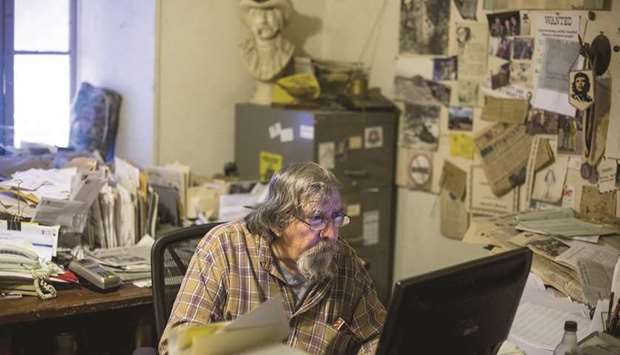 HOLDING FORT: Editor-publisher Don Russell in the Mountain Messenger newsroom. The walls of the newsroom u2014 where he simultaneously typed, smoked and readied the next dayu2019s paper u2014 are layered with newspaper clippings, mementos and nicotine.