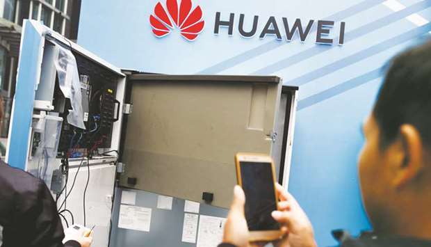 A man takes pictures of an open vending machine at a Huawei promotional stall in Huaqiangbei Commercial Street, a market place for Chinese producers and international wholesale buyers, in Shenzhen, Guangdong province. China boasts the worldu2019s biggest smartphone market, but a slowing economy, exacerbated by a trade war with the United States, has seen demand for gadgets drop across the tech sector.