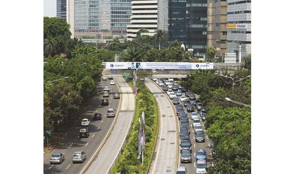 Traffic moves along a road in front of high-rise buildings in downtown in Jakarta (file). The finance ministry expects to use 28.43tn rupiah ($1.96bn) of 2019 sukuk proceeds to build 619 projects encompassing roads, ports, airports and railways in the country.