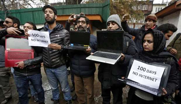 Kashmiri journalists display laptops and placards during a protest demanding restoration of internet service, in Srinagar, November 12, 2019