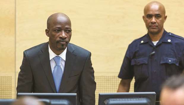 File photo shows Charles Ble Goude of Ivory Coast (left) entering the courtroom of the International Criminal Court (ICC) for his initial appearance in The Hague.