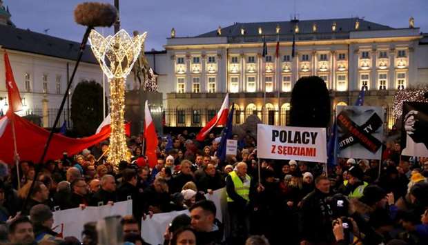 People walk past the Presidential Palace as they protest against judiciary reform in Warsaw, Poland