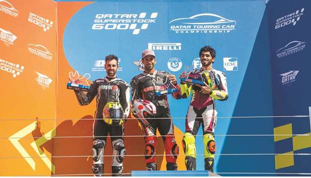 Winner Saeed al-Sulaiti (centre), second-placed Julian Simon (left) and third-placed Abdulla al-Qubaisi pose with the trophies on the podium for Race 1 of the second round of the Qatar Superstock 600 at Losail International Circuit.