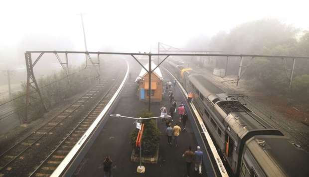 Train passengers alight at the Katoomba railway station as fog mixed with bushfire smoke fills the sky in the Blue Mountains, some 75km from Sydney, yesterday.