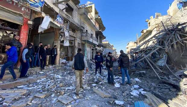 Syrians gather amidst the rubble following regime air strikes on a market in the town of Binnish in Syriau2019s northwestern province of Idlib
