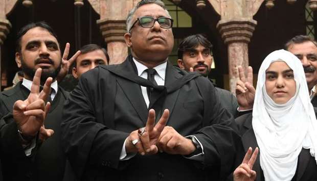 Azhar Siddique, the lawyer of former military ruler Pervez Musharraf, gestures alongwith team members outside the High Court building after a court decision in Lahore