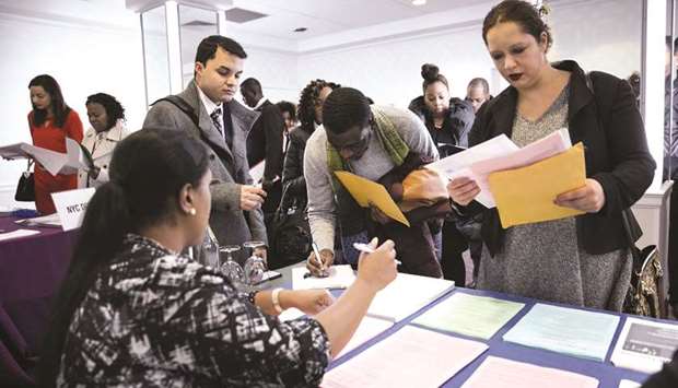 New York Department of City Administrative Services representative, left, speaks with job seekers during a Catalyst Career Group job fair in New York, in this February 7, 2018, photograph. The rate at which people in their prime working years hold jobs is higher than it has been in over a decade.