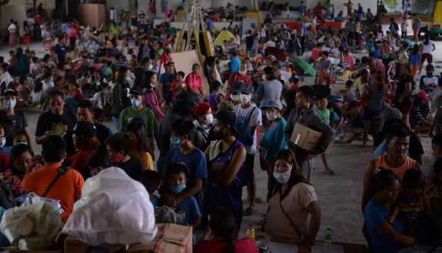 Evacuees from towns affected by the eruption of Taal volcano queue up at an evacuation center in Tanauan town, Batangas province south of Manila