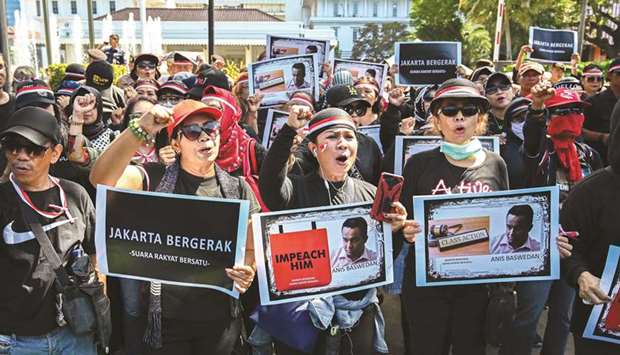 Activists hold up placards and shout slogans during a rally against Jakarta Governor Anies Baswedan in front of City Hall in Jakarta yesterday.