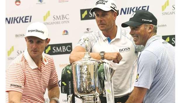 Justin Rose of England (left), Henrik Stenson of the United States (centre) and Matt Kuchar pose with the trophy after a press conference in Singapore yesterday. (AFP)