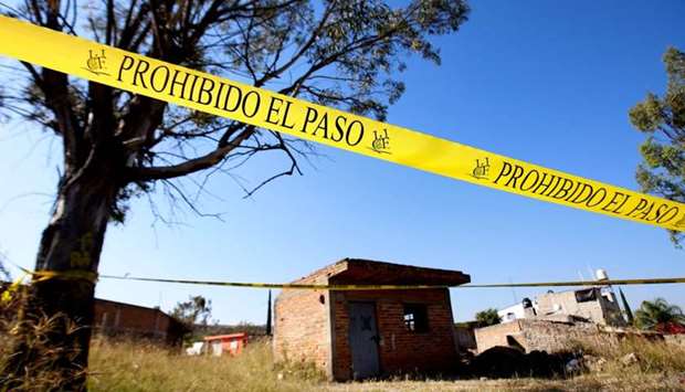 The area around a clandestine mass grave discovered at El Mirador neighbourhood in Tlajomulco de Zuniga, Jalisco State, Mexico, is cordoned-off as staff of the Office of the Special Prosecutor for Missing Persons works at the site