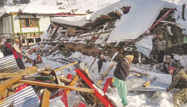 Local residents remove the debris of a collapsed house following heavy snowfall that triggered an avalanche in Neelum Valley, in Pakistan-administered Kashmir.