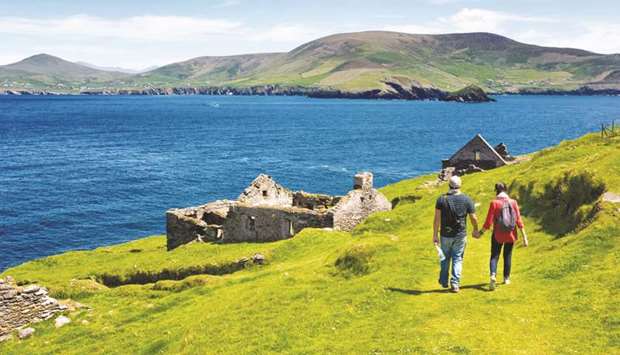 Visitors walk by the remains of a village on Great Blasket. Caretaker jobs on the island include free accommodation and food and spectacular views of Irelandu2019s most westerly point.