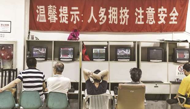 Investors sit at trading terminals at a securities brokerage in Shanghai. The bourse ended down 0.5% to 3,090.04 points yesterday.
