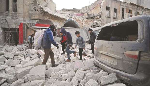 Syrians make their way through the rubble of a building following a regime air strike on Ariha town in Syriau2019s last major opposition bastion of Idlib, yesterday.