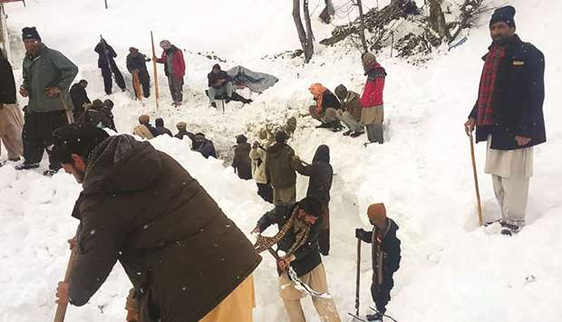 Local residents search for the avalanche victims in the snow in Neelum Valley, in Pakistan-administered Kashmir yesterday.